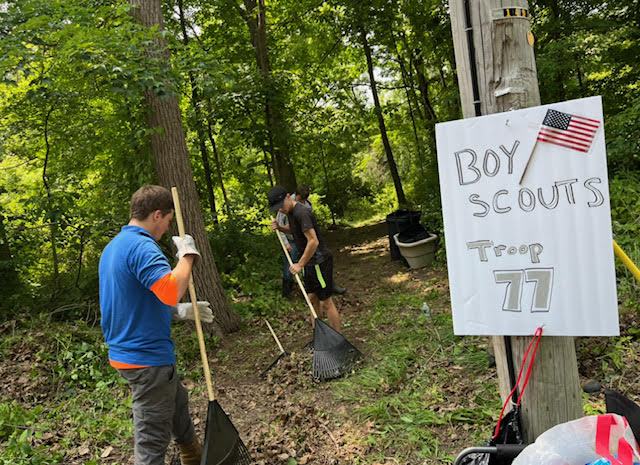 Boy Scout Troop 77 raking up debris in the cemetery