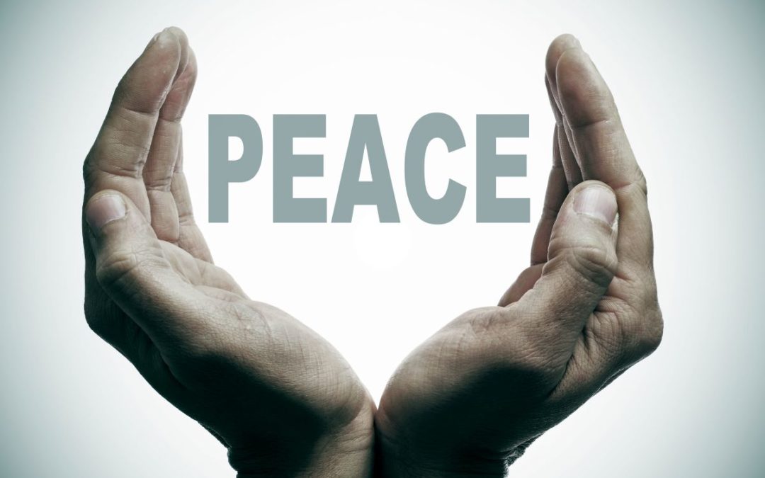 A hand holding the word PEACE