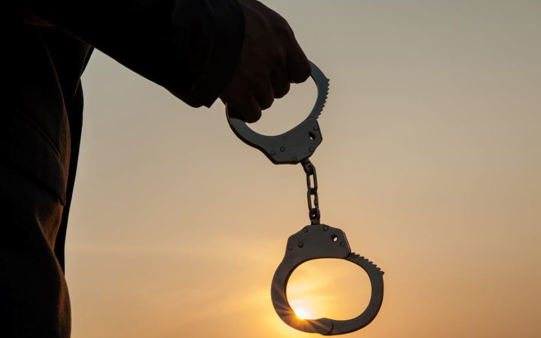 person dangling handcuffs from his hand