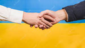 Two business people shaking hands in front of the ukrainian flag.