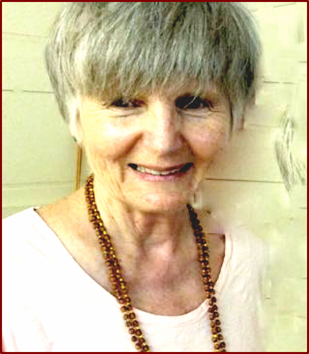 Smiling elderly woman with short gray hair wearing a necklace against a light background.