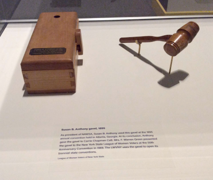 A wooden gavel and block on display in a museum, with informational plaques describing their historical significance in voting rights conventions.